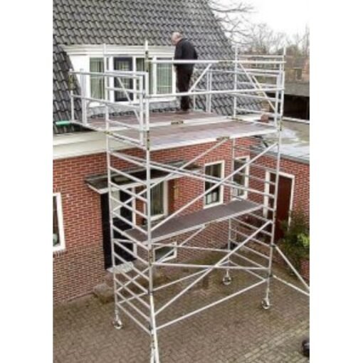 man staat op daksteiger bij een dakkapel. Uitgezoomde foto zodat de hele steiger zichtbaar is