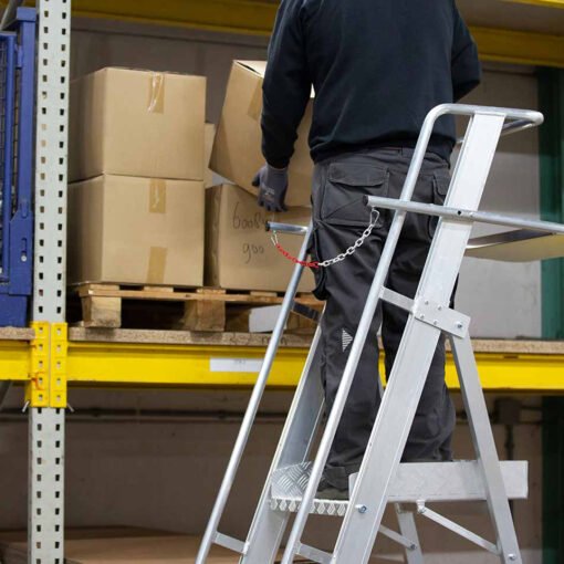 Man staat op een eurostairs magazijntrap easy te werken in een magazijn